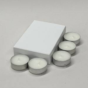 May include: A white box with six small, white, unscented tea light candles.