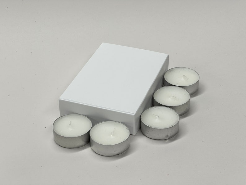 May include: A white box with six small, white, unscented tea light candles.