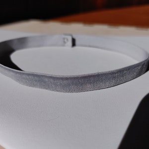 May include: A gray velvet choker necklace with a simple design.