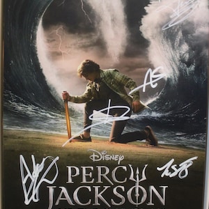 May include: A poster for the Disney+ series "Percy Jackson and the Olympians" featuring a young person kneeling on a beach with a large wave behind them. The poster includes the Disney+ logo and signatures.