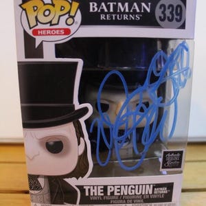 May include: A Funko Pop! vinyl figure of The Penguin from Batman Returns, number 339, in its original box. The box features the Batman Returns logo and a blue autograph on the front.