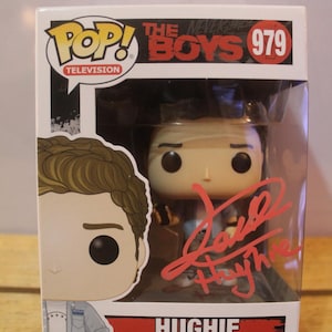 May include: A Funko Pop! vinyl figure of Hughie from The Boys television series. The figure is in its original packaging, with a clear plastic window. The box features the Pop! Television logo and the number 979.