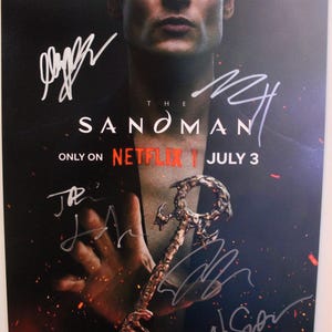 Könnte beinhalten: Poster für "The Sandman" auf Netflix, mit einem Mann, Unterschriften und einem Schlüssel. Das Poster hat einen dunklen Hintergrund mit dem Titel der Show und dem Netflix-Logo. Der Schlüssel ist verziert und metallisch.