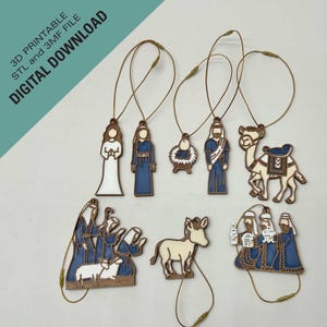 Puede incluir: Un conjunto de adornos navideños con figuras religiosas y animales. Los adornos son de madera marrón con detalles azules y blancos. Cada adorno tiene una cuerda dorada para colgar. El texto "3D PRINTABLE STL and 3MF FILE DIGITAL DOWNLOAD" es visible.