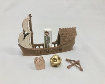 Puede incluir: Un barco de madera marrón con una vela blanca, una pequeña figura de una persona de pie en el interior, un cuenco de metal dorado, un pequeño cofre de madera y un arco y flecha de madera marrón.