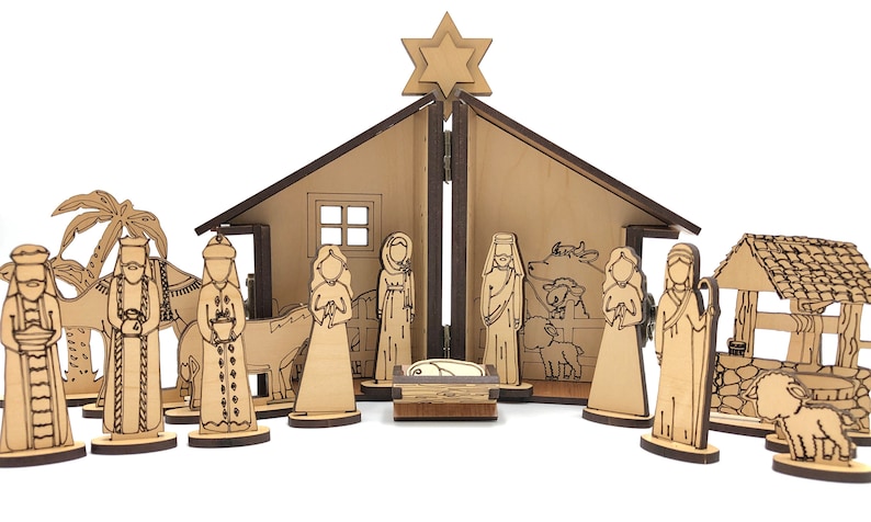 May include: A wooden nativity scene set with a brown wooden stable, a star on top, and 15 figures including Mary, Joseph, baby Jesus, three wise men, a donkey, a camel, a cow, a sheep, and a shepherd. The figures are all standing on small wooden bases.