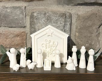 May include: White ceramic nativity scene with a stable, figures, and a star. The stable has the words "O Holy Night" written on it.