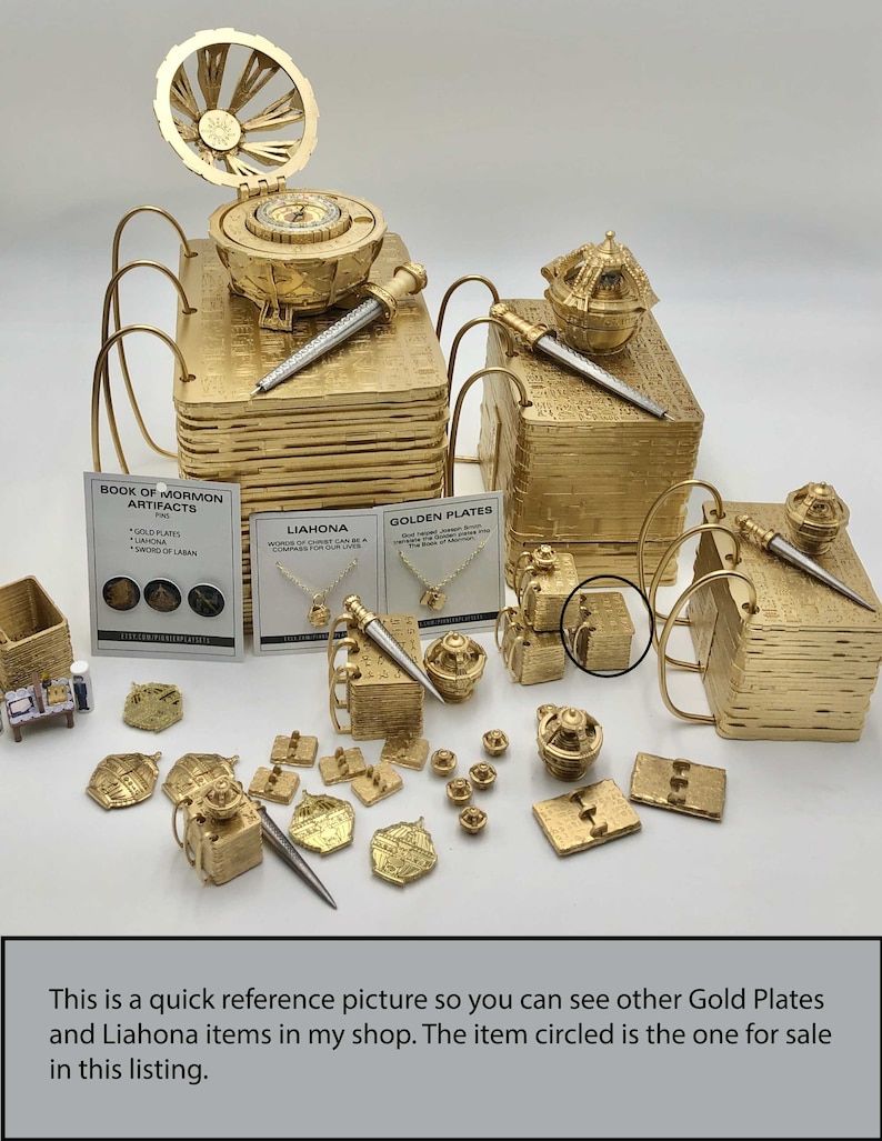 May include: A collection of gold-colored artifacts, including miniature books, pens, compasses, and jewelry. The image includes text that reads "BOOK OF MORMON ARTIFACTS" and "GOLDEN PLATES". The text also states "This is a quick reference picture so you can see other Gold Plates and Liahona items in my shop."