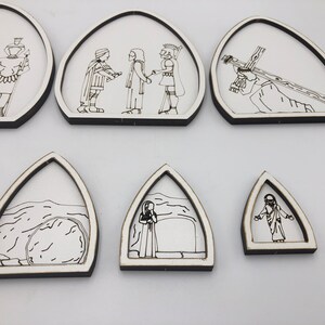 May include: Set of six white wooden arches with black line drawings depicting scenes from the Passion of Christ. The scenes include Jesus carrying the cross, Jesus being nailed to the cross, Jesus being taken down from the cross, Jesus being buried, and Jesus rising from the tomb.