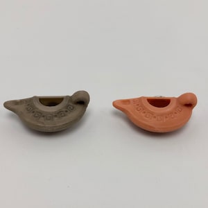 Puede incluir: Dos peque&ntilde;as l&aacute;mparas de aceite de cer&aacute;mica, una es marr&oacute;n y la otra naranja. Ambas l&aacute;mparas tienen un dise&ntilde;o decorativo alrededor del borde.