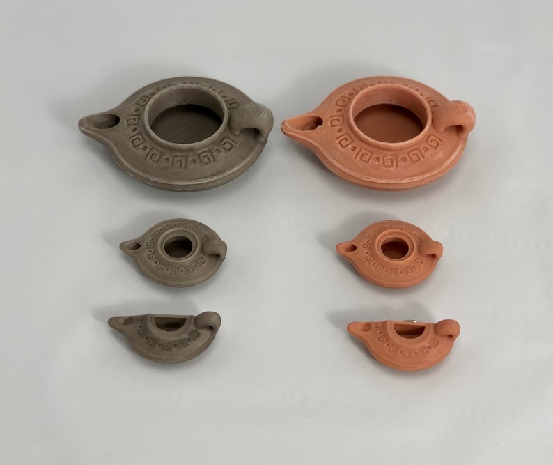Puede incluir: Cinco l&aacute;mparas de aceite de terracota de diferentes tama&ntilde;os. Las l&aacute;mparas son todas marrones y tienen un dise&ntilde;o sencillo con un peque&ntilde;o agujero en el centro para la mecha. Las l&aacute;mparas est&aacute;n dispuestas en una fila de la m&aacute;s grande a la m&aacute;s peque&ntilde;a.