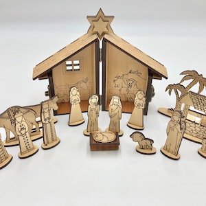 May include: A wooden nativity scene set with a stable, a star, a camel, a shepherd, a well, palm trees, and figures of Mary, Joseph, and baby Jesus.