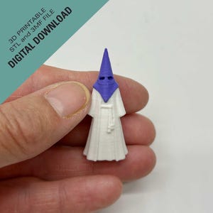 May include: A small 3D printed figurine featuring a white robe and a purple pointed hood with eye holes. The text 3D PRINTABLE STL and 3MF FILE DIGITAL DOWNLOAD is visible in the corner. This object represents a figure in traditional attire.