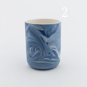 May include: A blue and white marbled ceramic mug. The mug has a swirling pattern of blue and white.