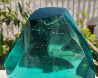 Peut inclure: Un grand presse-papier en verre bleu turquoise facetté. Le verre est transparent et a une légère teinte verte.