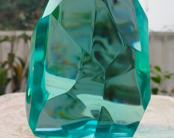 Peut inclure: Une grande sculpture en verre bleu turquoise facetté ressemblant à une pierre précieuse. La sculpture a une surface lisse et polie et est façonnée comme un grand cristal irrégulier.