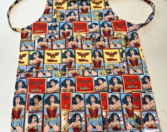 May include: A blue and red Wonder Woman themed apron with multiple pockets. The apron has a repeating pattern of Wonder Woman images and the words "Fight for Justice".