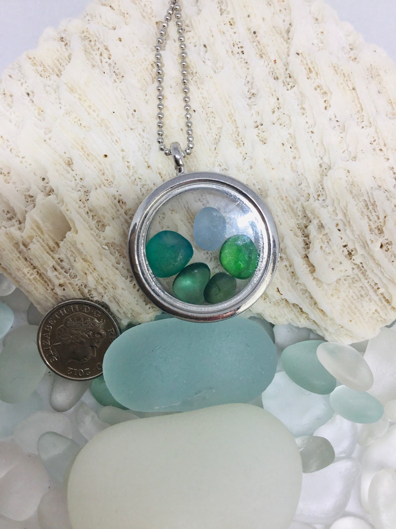 Memory locket with pieces of seahams historic seaglass in shades of blue and green