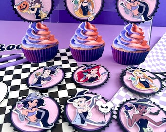 May include: Cupcakes with purple and orange frosting, decorated with Halloween-themed character toppers. The toppers feature cartoon princesses in witch hats and other Halloween designs. The cupcakes are arranged on a purple surface.