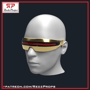 Puede incluir: Una visera de color dorado con una franja de lente roja horizontal en el centro, colocada sobre una cabeza de maniquí blanca. La visera presenta un diseño envolvente y elegante que cubre el área de los ojos, con acabado metálico y marco negro.