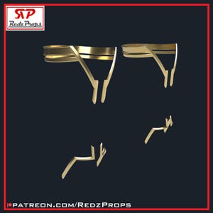 May include: Gold-colored, geometric-shaped accessories are displayed against a dark background. The accessories include two larger pieces and two smaller pieces. The Redz Props logo is in the top left corner, and the Patreon URL is at the bottom.