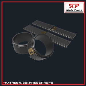 May include: A set of black metal wrist cuffs with gold accents. The cuffs are designed to be worn on the wrists and have a locking mechanism. The cuffs are made of metal and have a smooth, polished finish.