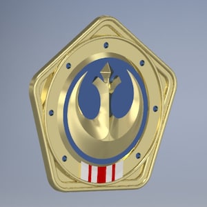 May include: A gold-colored, five-pointed star-shaped coin with a blue and gold Rebel Alliance symbol in the center. The coin has a red, white, and blue stripe design around the edge.