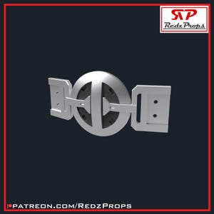 May include: A silver-coloured belt buckle with a circular design featuring a black centre and a silver outer ring. The buckle has two rectangular sections on either side of the circular design.