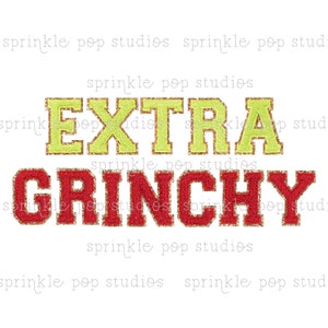 May include: A green and gold "EXTRA" and red and gold "GRINCHY" text graphic with a glittery finish.