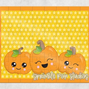 May include: A yellow jigsaw puzzle with a background of yellow stars. The puzzle features three orange pumpkins with cute faces. The text "Sprinkle Pop Studios" is at the bottom of the puzzle.