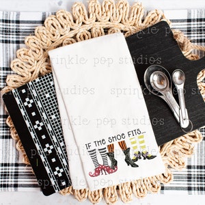 May include: White kitchen towel with a black and white checkered pattern and the text "If the shoe fits..." with a graphic of four witches' legs wearing different shoes.