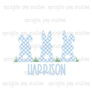 May include: Three blue gingham Easter bunny silhouettes with white fluffy tails, standing in green grass. The name "HARRISON" is written in blue script below the bunnies. The background is white.