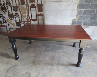 May include: A rectangular wooden table with a dark red top and black legs. The table has a gray painted base and a simple design.