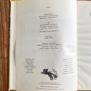 Peut inclure: Page d'un livre ouvert avec du texte listant le personnel, l'art et les cr&eacute;dits de production. La page est tir&eacute;e d'une publication de 1969, avec une petite illustration d'une figure avec une arbal&egrave;te. Le livre est ouvert sur une surface en bois.