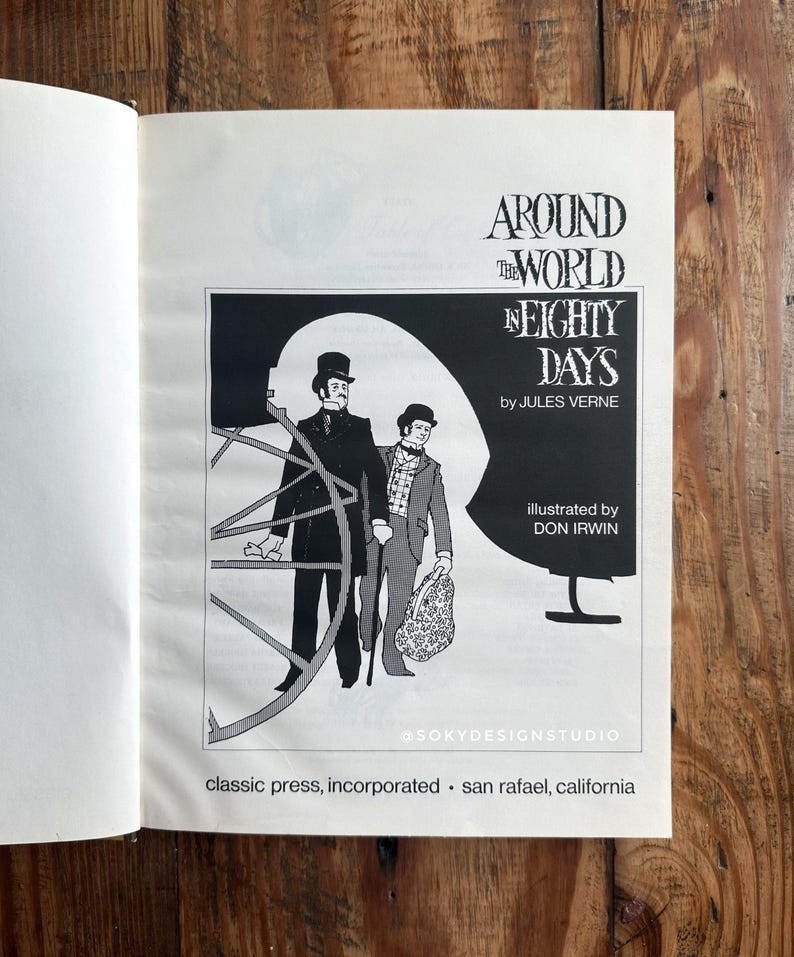 Peut inclure: Livre ouvert avec une illustration en noir et blanc de "Le Tour du monde en quatre-vingts jours" de Jules Verne. L'image montre deux hommes en costume d'&eacute;poque, avec le nom de l'auteur et de l'illustrateur.