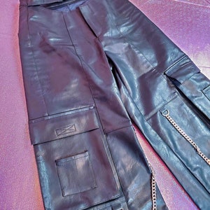 May include: Black leather cargo pants with a silver chain detail and multiple pockets.