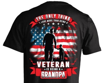 May include: Black t-shirt featuring a red, white and blue American flag design. The text "The only thing I love more than being a Veteran is being a Grandpa" is printed on the shirt.