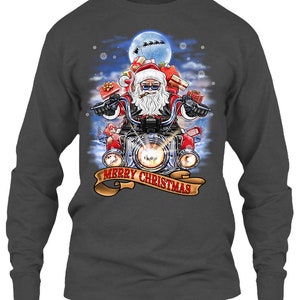 May include: Dark gray long-sleeve shirt featuring a graphic of Santa Claus riding a motorcycle, carrying gifts. The design includes a full moon, snowflakes, and the text "MERRY CHRISTMAS" on a banner.