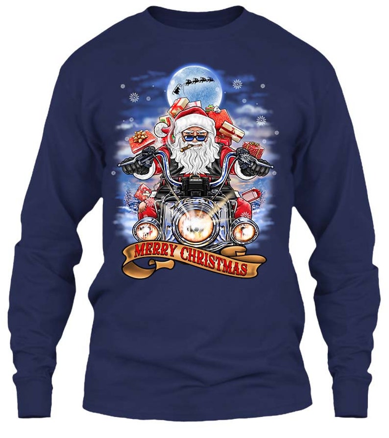 May include: Navy blue long-sleeve shirt featuring a graphic of Santa Claus riding a motorcycle, carrying gifts. The design includes a full moon, snowflakes, and the text "MERRY CHRISTMAS" on a banner. The shirt is a festive holiday item.