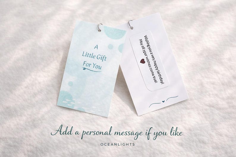 May include: Two white gift tags with silver metal loops. One tag reads "A Little Gift For You" with blue watercolor accents. The other tag has a birthday message and a heart. The text "Add a personal message if you like" is below.
