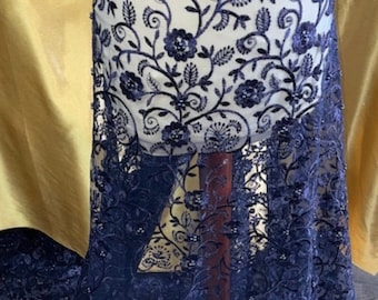 May include: Navy blue embroidered lace fabric with a floral pattern and beaded accents.