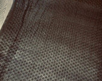 May include: Black fabric with a small, repeating pattern of raised dots.