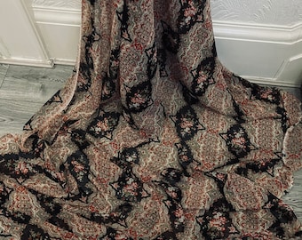 May include: Black sheer fabric with a paisley and floral print. The fabric has a soft, flowing texture.