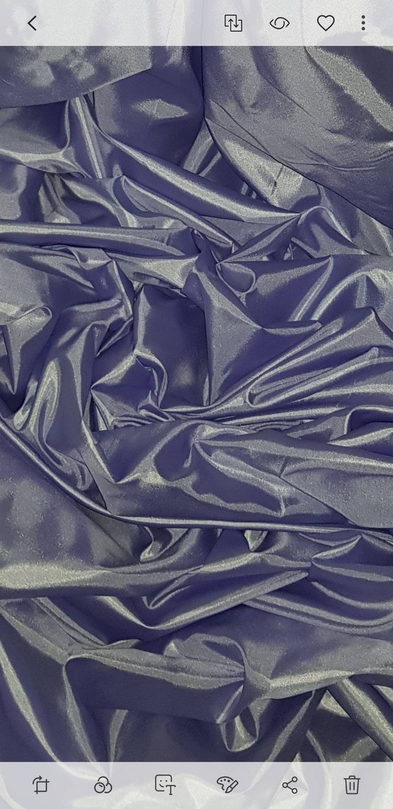 May include: A close-up of a deep purple satin fabric with a smooth, silky texture. The fabric is folded and draped, creating a luxurious and elegant look.