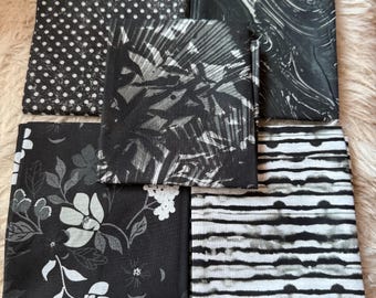 May include: Five black and white fabric squares with different patterns. The patterns include polka dots, stripes, floral, and abstract designs.