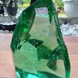 Op de afbeelding: Een groot, groen glazen beeld met ingesloten luchtbellen. Het beeld is bergvormig en weegt 3,1 kg.