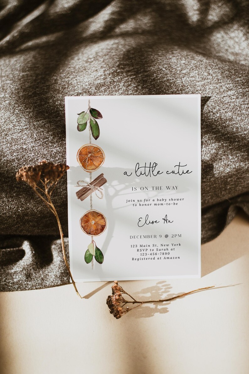 K&ouml;nnte beinhalten: Eine Babyparty-Einladung mit dem Text "a little cutie is on the way". Die Einladung zeigt Aquarellillustrationen von getrockneten Orangenscheiben, Zimtstangen und Gr&uuml;nzeug. Die Details umfassen Datum, Uhrzeit und Ort.