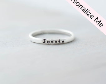 May include: A silver ring with the name "Jessie" engraved on it.