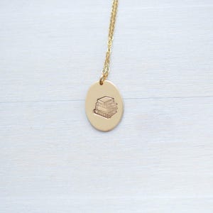 image of gold-filled literary gift necklace stamped with a stack of books
