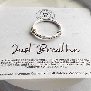 Pu&ograve; includere: Anello d'argento con la scritta "just breathe" incisa sulla fascia. L'anello &egrave; su una carta bianca con la scritta "Just Breathe" in corsivo e un messaggio sulla calma. Fatto a mano.